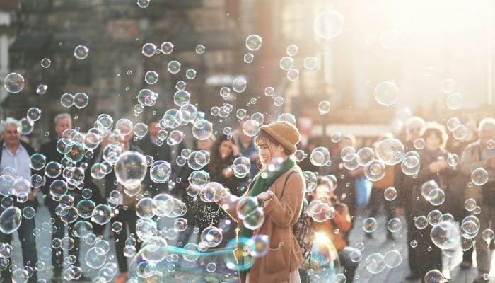 Woman in a city with scattered soap bubbles